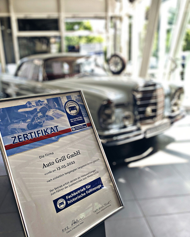 Urkunde Fachbetriebe für historische Fahrzeuge vor einem Mercedes Oldtimer