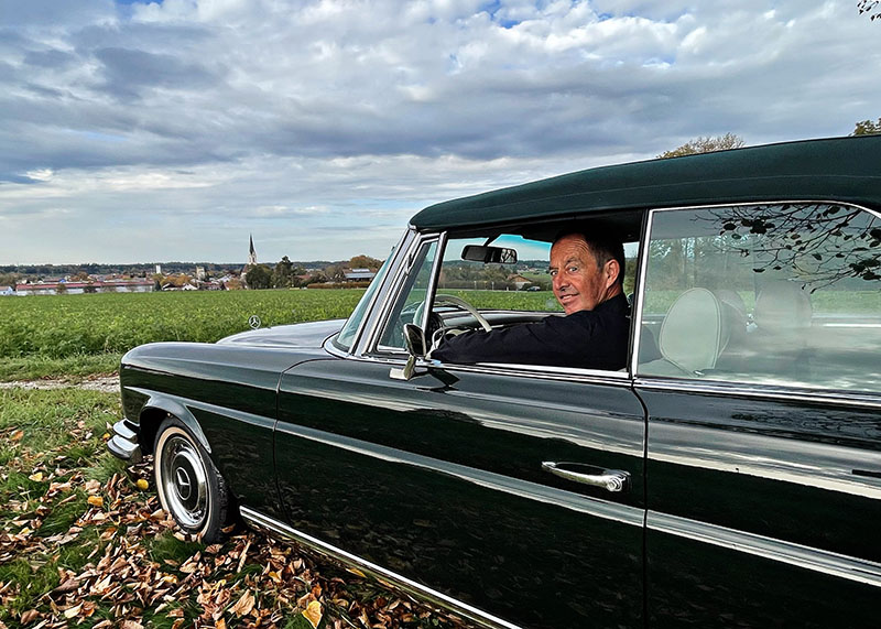 Ansprechpartner für Leistungen aus dem Auto Grill Classic Center, Günther Greißl sitzt im Mercedes-Benz 220 SE Coupé in 834 Moosgrün.