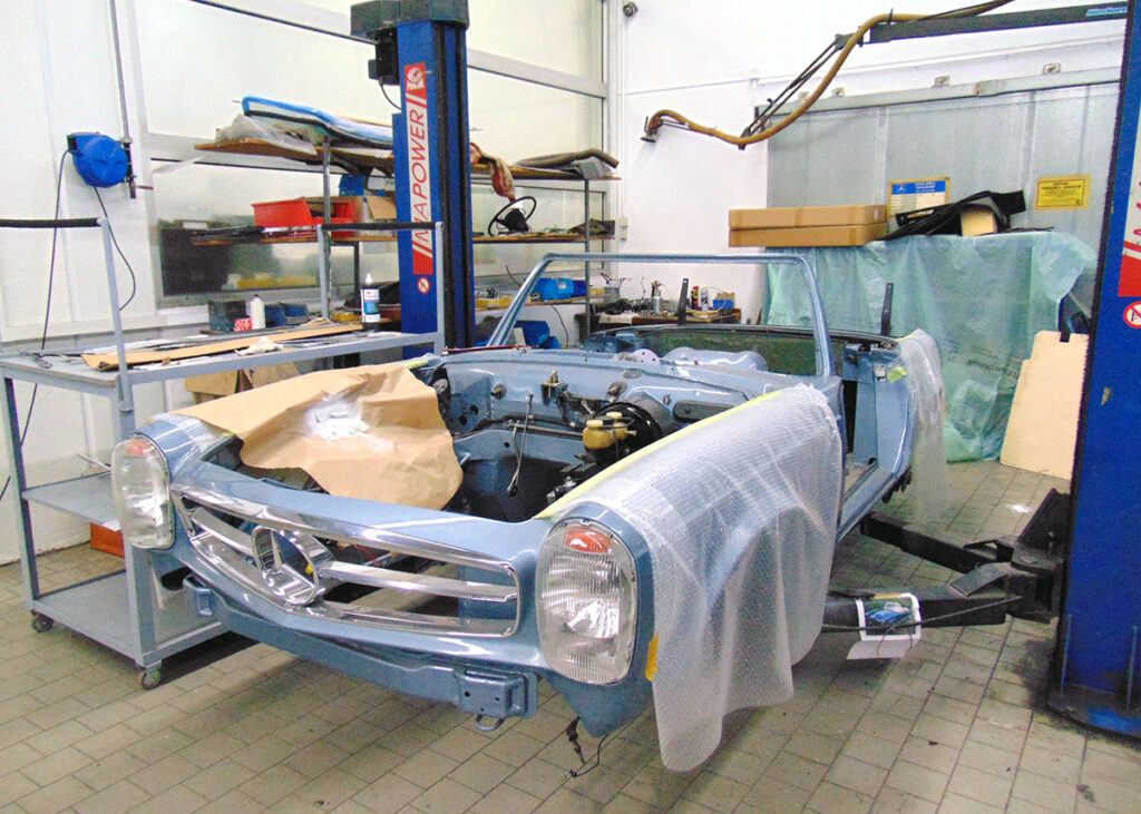 Ein auseinander gebauter Mercedes-Benz W113 SL Pagode in der Werkstatt bei Auto Grill
