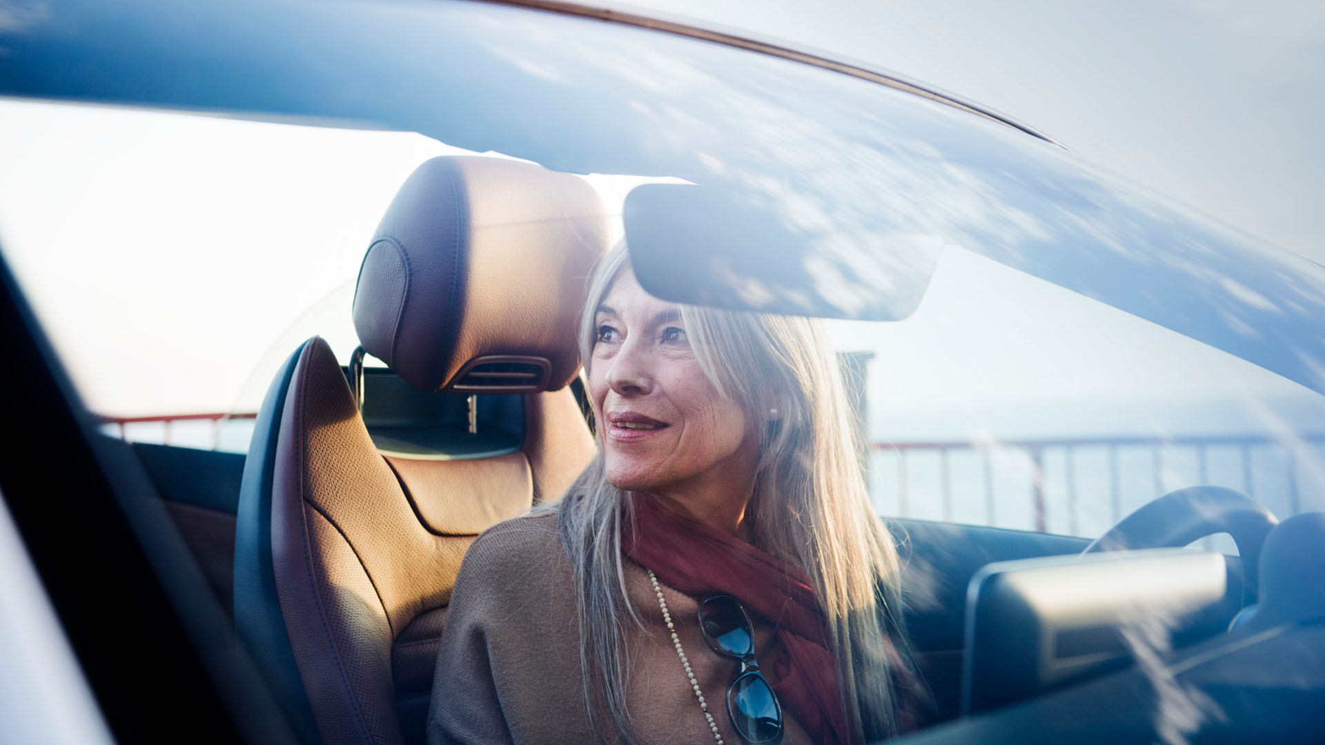 Eine ältere Dame genießt die Fahrt in Ihrem Mercedes-Benz Cabrio